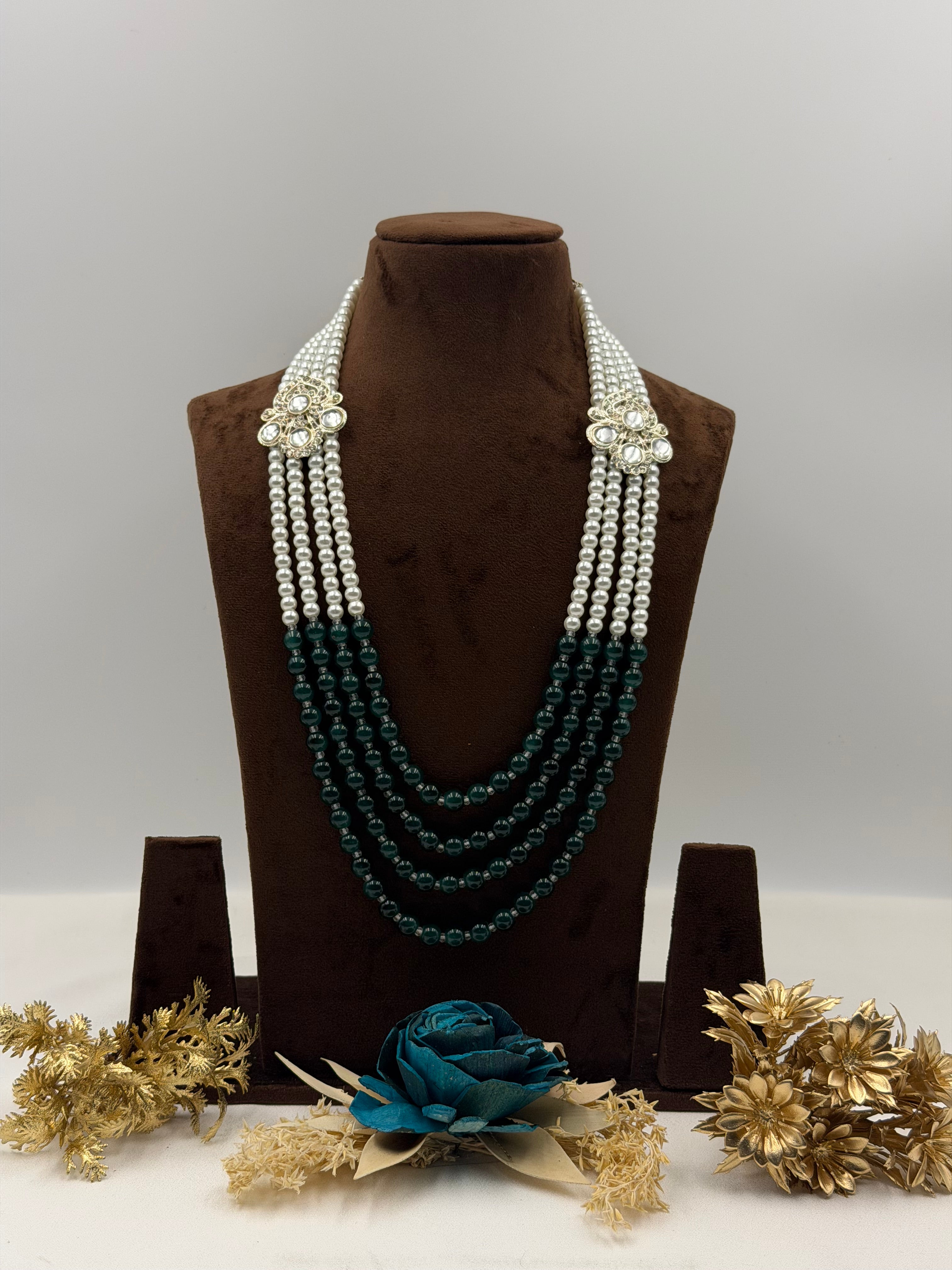 Set of pearl necklaces on a brown velvet stand with decorative elements.